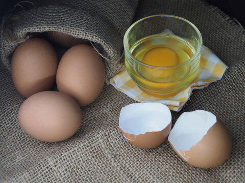 Fresh Chicken Eggs In Rustic Bag And Broken Egg Shells.