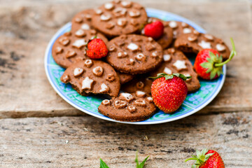  Home made chocolate chip cookie with strawberryes s on a plate