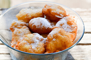 Traditional Bulgarian home made deep fried  patties  covered with sugar  оn rustic backgroud.Mekitsa or Mekica,  on wooden  rustic  background. Made of kneaded dough that is deep fried 