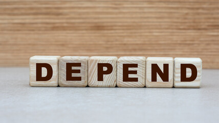 concept of the word DEPEND on cubes on a wooden background