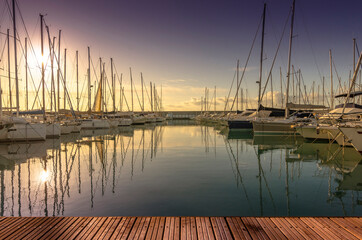 Marina with walkway and boats at sunset