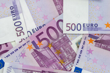 Banknotes of five hundred and 500 euros are scattered in a chaotic manner. European currency lies on the table. Blank for design, background. View from above.