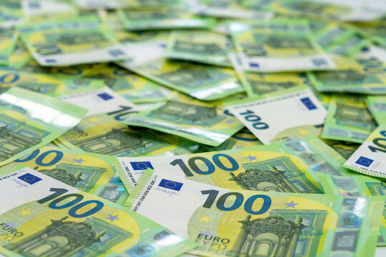 Banknotes of 100 hundred euros are scattered in a chaotic manner. European currency. Side view, close-up. Blank for design, background.