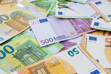 European currency lies on the table. Banknotes one hundred, two hundred, fifty, five hundred euros are scattered in a chaotic manner. Blank for design, background. Side view.