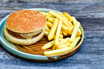   Home made  chicken Burger and   deep fried french fries on wooden   cutingboard 