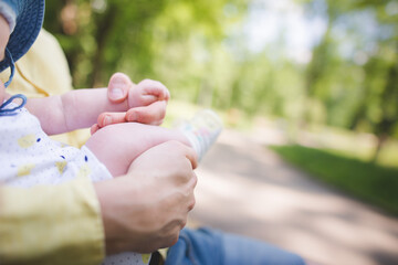 baby girl holding father's hand in a park, sitting on dad's laps, and showing love and emotions, father and daughter 