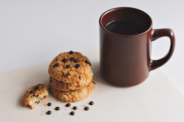 A Cup of coffee and American cookies with chocolate chips on a white background. The view from the top.