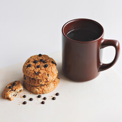 A Cup of coffee and American cookies with chocolate chips on a white background. The view from the top.