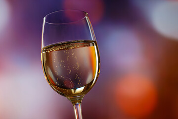 A glass of champagne on a background of colored lights.