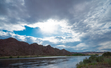Sunset in the steppe in a river valley. Beautiful sunset. Landscape in the steppe, Prairie. Landscape in the evening. The clouds.
