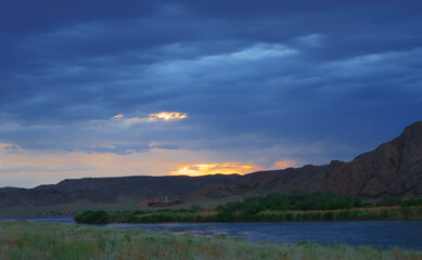 Sunset in the steppe in a river valley. Beautiful sunset. Landscape in the steppe, Prairie. Landscape in the evening. The clouds.