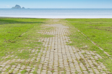 green grass and walkway and blue sea