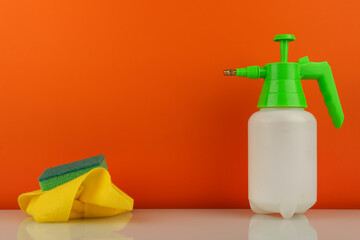 cleaning product in spray bottle on orange background with copy space
