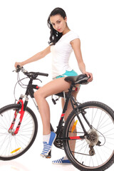 Young woman in sport wear posing on bicycle