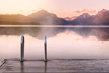 Beautiful calm peaceful scenic foggy lake and mountains view from wood decking, relaxation, tranquility, wanderlust