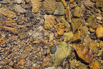 Kamienie rzeczne  rzeki Skawa obmywane jej wodami w promieniach słońca.