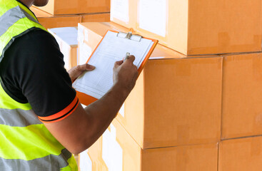 Warehouse worker holding clipboard and checking order shipment boxes. warehouse inventory management.