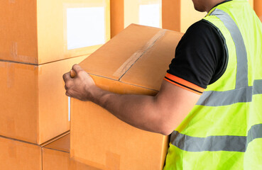 Worker courier lifting shipment boxes, packaging, cardboard box, warehouse delivery service shipping goods at manufacturing warehouse.