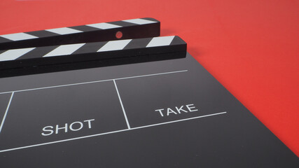 Fototapeta na wymiar black Clapperboard or movie slate. it use in video production or film and cinema industry on red background.