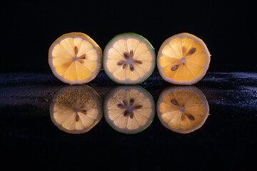 fresh sliced lemon and reflection on black background