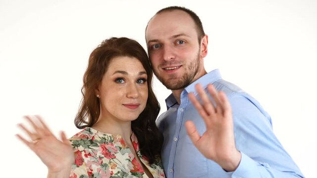 Young couple smiling waving hands on white background
