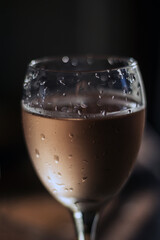 A glass of wine with light and drops