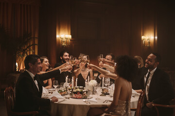Socialites celebrating with wine at dinner party