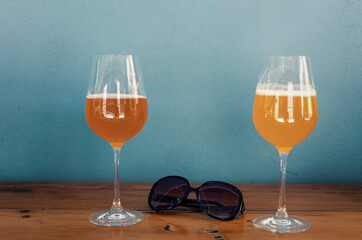 Selective focus on two glasses of cold beer on a wooden table.