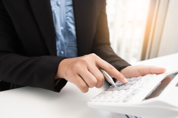 Business woman is using calculator for calculate income in the office room.