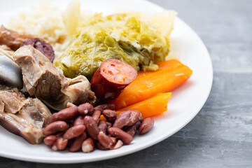typical portuguese dish boiled meat, smoked sausages, vegetables and rice on white plate