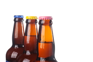Row of brown beer bottles over white background. Beer with colored caps. Close up view of drinks with copy space.