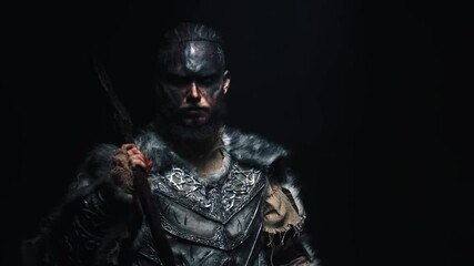 The brutal Viking cast his axe on his shoulder and shouts into the camera. A Scandinavian warrior in war paint puts an axe on his shoulder and shouts frighteningly at the camera - Powered by Adobe