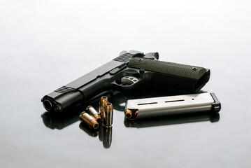 Hefty 1911 semi automatic handgun unloaded next to 8 round magazine and 4 loose hollow point...