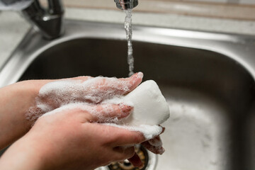 girl washes hands with soap in the wash basin
