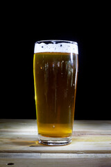 Close up Beer Glass with Light painting background. Amazing abstract colored lights in motion. Magical light in a glass of craft beer.