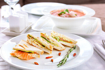 Sandwiches with salmon on a white plate. Serving in a restaurant.
