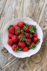 Topview shot of strawberries in a white rustic bowl