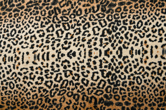 Brown with black leopard print on soft fabric. Animal fur print as background.