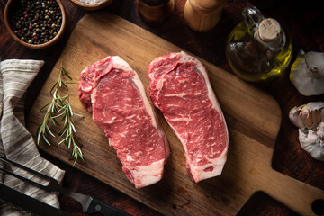raw strip beef steak meat on wooden cutting board