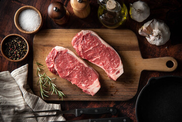 raw strip beef steak meat on wooden cutting board - Powered by Adobe
