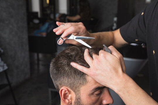 hombre peluquero cortando el pelo a cliente