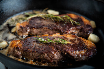 cooking new york strip steak on skillet pan
