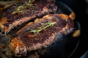 cooking new york strip steak on skillet pan