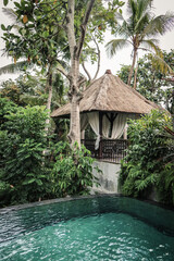 Swimming pool near traditional balinese cozy gazebo