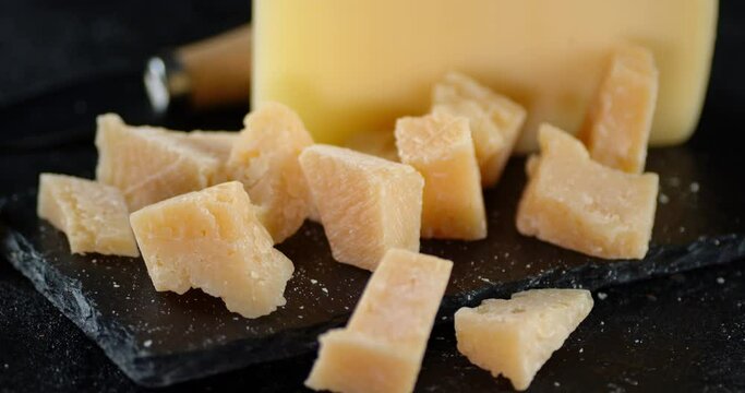 Pieces of Parmesan cheese on a stone Board rotate slowly.