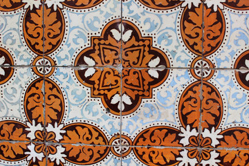 Azulejo de estilo portugués en tonos anaranjados, marrones y blancos. Es una decoración típica de Portugal, de la zona de Lisboa