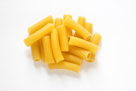 traditional italian pasta isolated on white background, heap of tortiglioni pasta, durum wheat noodles