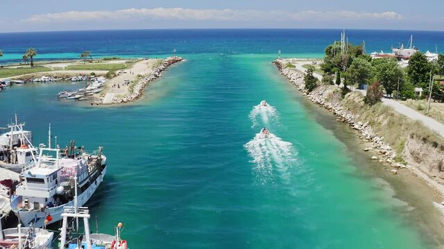 Aerial footage of two motor boats crossing Nea Potidea canal, which connects Toroneos Bay with the Gulf of Thermaikos. Greece, Kassandra, Halkidiki