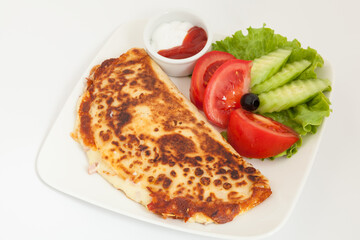 Classic omelet with cheese and tomatoes and cucumbers salad on a white plate