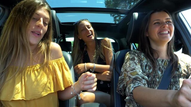 Happy mother with two daughters in car dancing after end of quarantine coronavirus slow motion